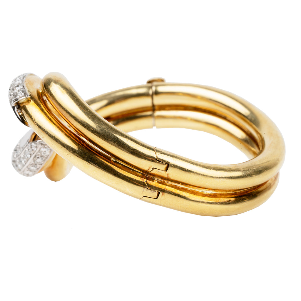 Finely crafted bangle in 18k gold and platinum set with 56 diamonds, approximated total weight 2.5 carats.American in origin. Circa 1970. Bracelet side. 