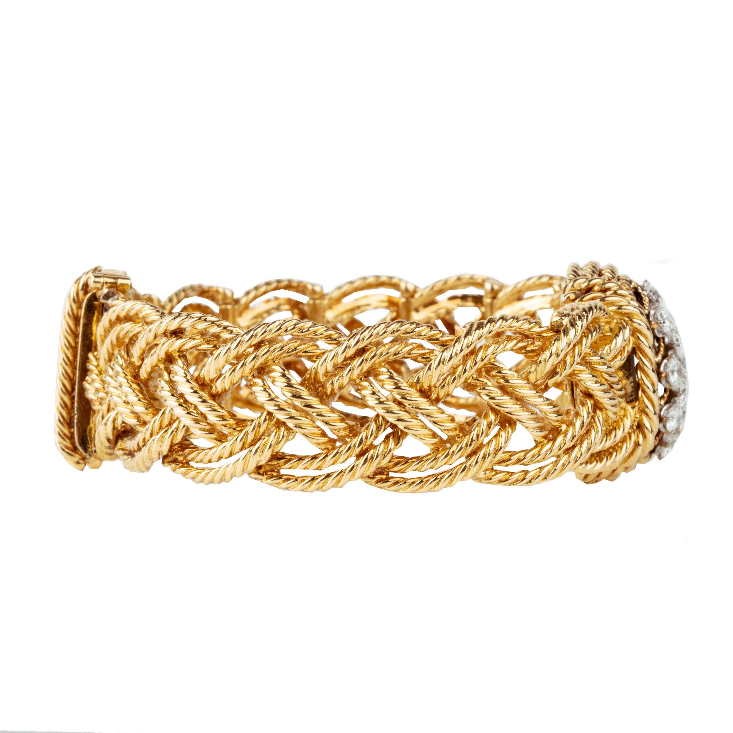 A braided 18k gold bracelet with a diamond panel that opens to reveal a diminutive watch face. The bracelet has an estimated diamond weight of 1.7 carats. Signed Boucheron, Paris. France, circa 1950.