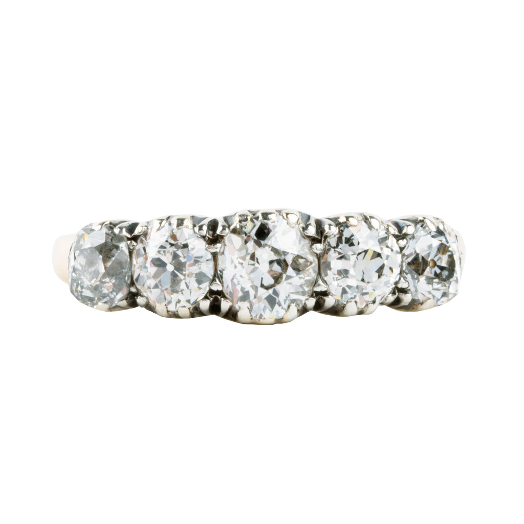 Victorian-era five-stone diamond ring, in a silver-topped gold setting. Five bright old mine-cut diamonds set in cutaway settings. England, circa 1860. Front view. 