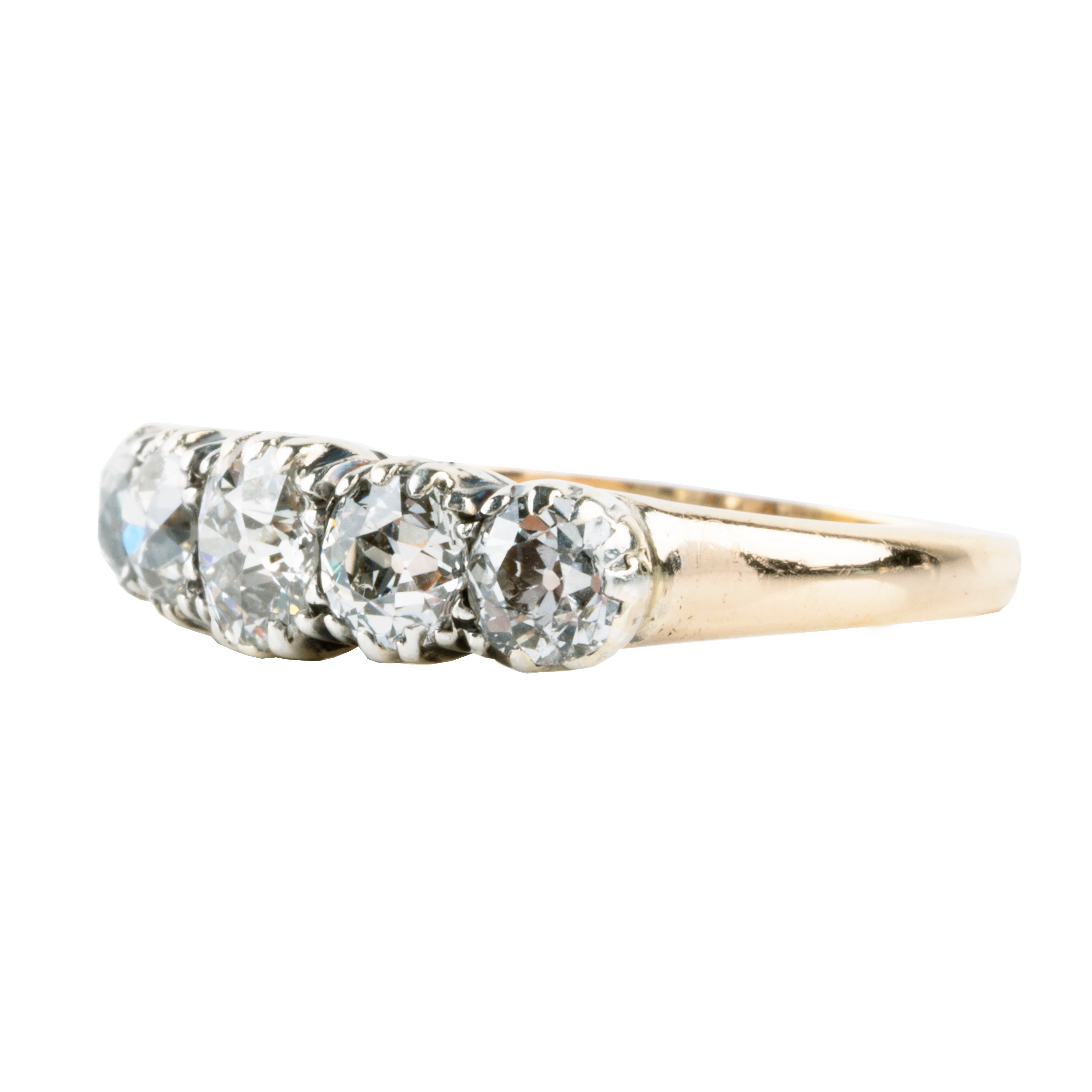 Victorian-era five-stone diamond ring, in a silver-topped gold setting. Five bright old mine-cut diamonds set in cutaway settings. England, circa 1860. Side view. 