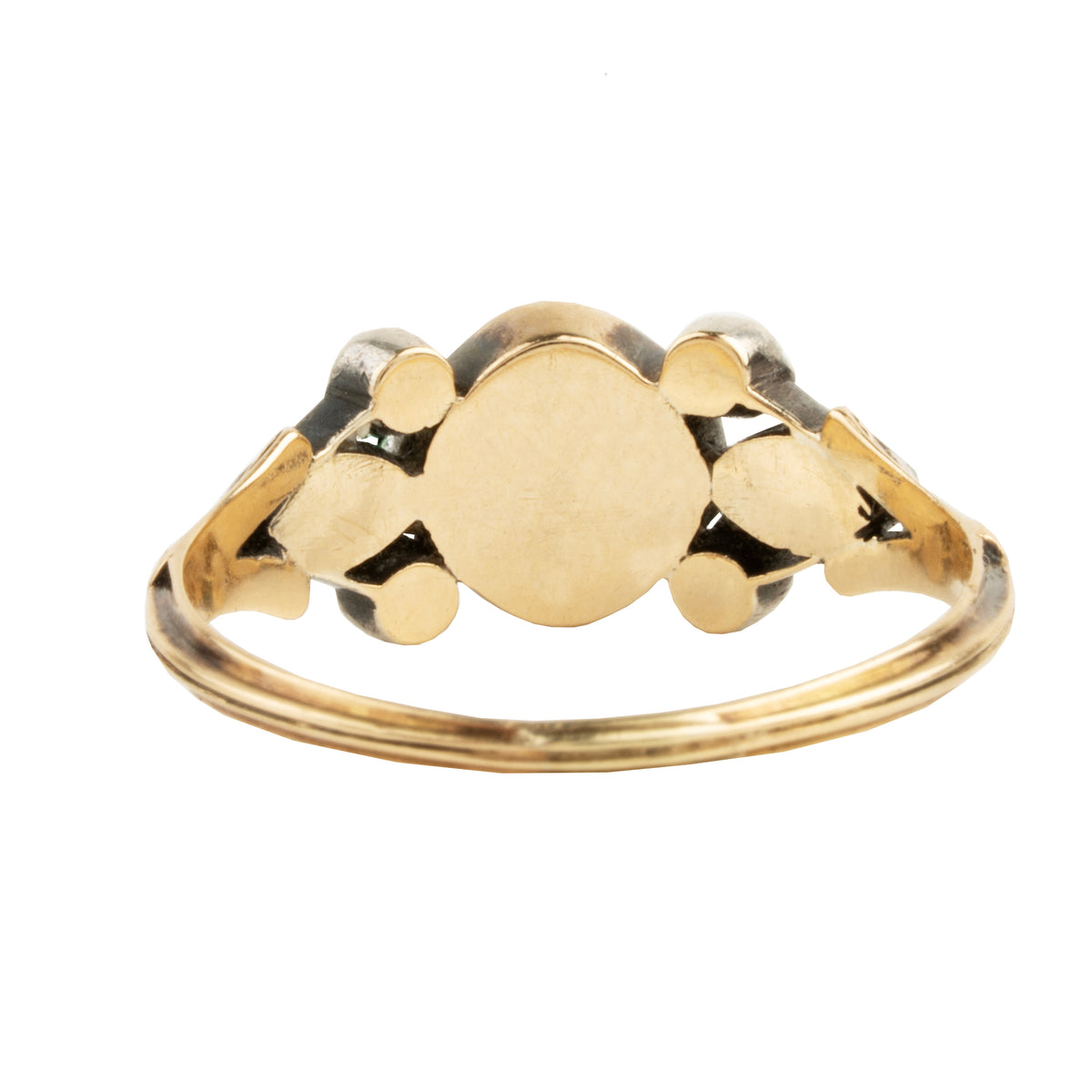 A gold signet ring with a flat, polished oval face and decorative side elements, shown on a plain white background.