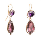 Lovely early 19th century earrings set in 15k gold. Cushion and pear shaped amethyst stones set in closed-back collet settings. The stones are a pale purple, with varied shades of purple and pink coming from the foil behind the stones. The coloring is very unique. English in origin. Circa 1800. Side view. 