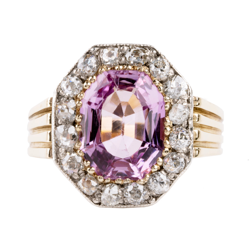 Striking ring with a large, vibrant pink precious topaz stone. It has very crisp clarity and rich color.&nbsp; The photographs do not capture the depth of color. There are sixteen mixed-cut antique diamonds surrounding the primary stone. Old Mine and old European cuts are set in platinum, while the rest of the ring is in 18k gold. England, circa 1900. Front view. 