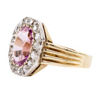 Striking ring with a large, vibrant pink precious topaz stone. It has very crisp clarity and rich color.&nbsp; The photographs do not capture the depth of color. There are sixteen mixed-cut antique diamonds surrounding the primary stone. Old Mine and old European cuts are set in platinum, while the rest of the ring is in 18k gold. England, circa 1900. Side view. 