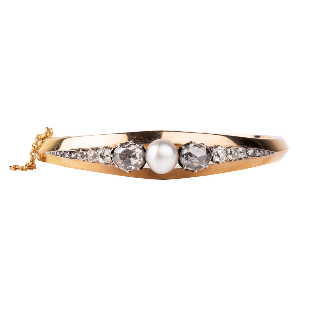 Approximately three carats of rose-cut diamonds are set in silver cut-away settings. The twenty diamonds flank a single natural pearl. The stones taper into a knife-edge detail in 18k rose gold. Continental Europe, circa 1860. Front view. 