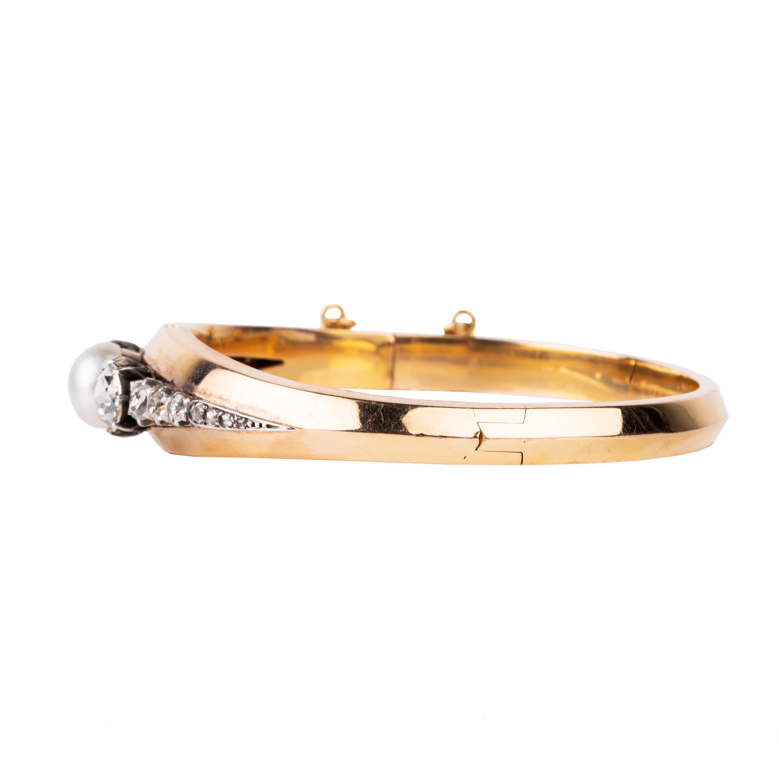 Approximately three carats of rose-cut diamonds are set in silver cut-away settings. The twenty diamonds flank a single natural pearl. The stones taper into a knife-edge detail in 18k rose gold. Continental Europe, circa 1860. Side view. 