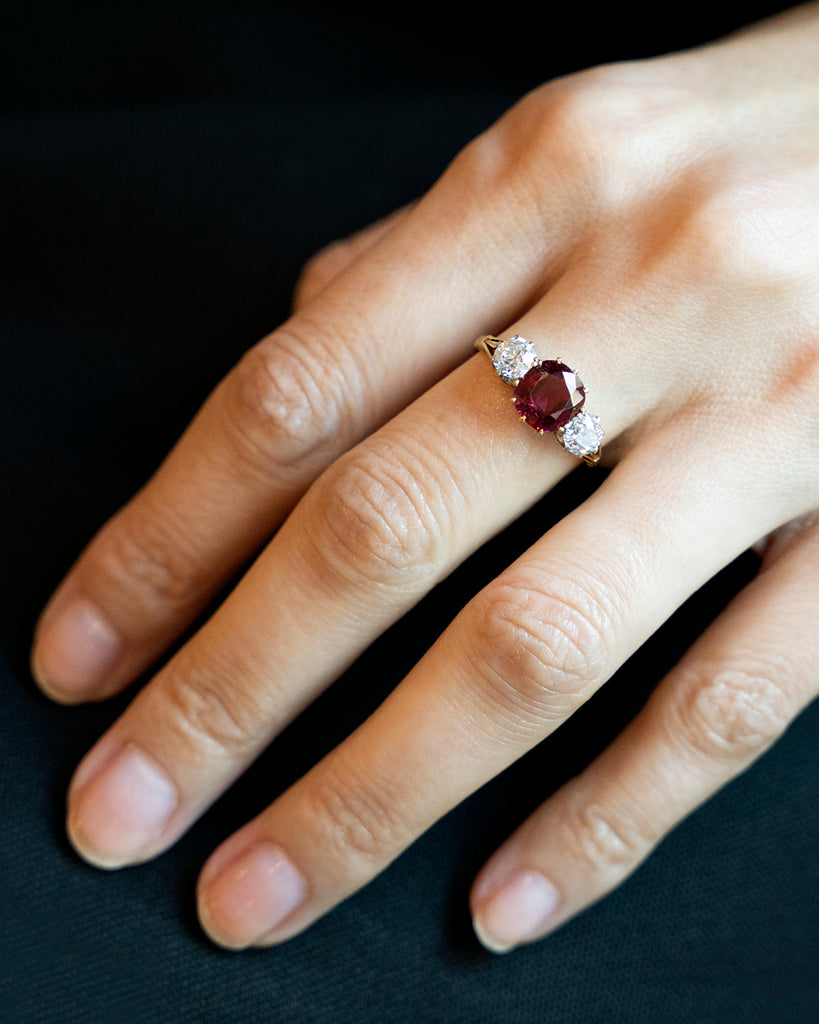 A classic ruby and diamond ring three stone ring. The ring features a natural red 2.11 carat ruby certified to have no treatment and be of Thai origin. The primary stone is flanked by two old European cut diamonds weighing approximately .5 carat each. The ring is set in 18k yellow gold and platinum.&nbsp; English in Origin. Circa 1910. The stone holds a certificate from GCS laboratory in London. Certificate number:5784-2538. The ring being modeled on hand. 