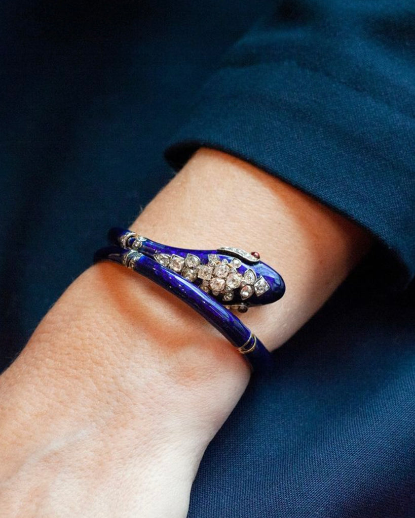 19th century snake bangle, set with both old mine cut and rose cut diamonds.ruby eyes. The body is crafted in 18k gold and hinged at 4 points allowing for a varied fit. English in origin. Circa 1860.