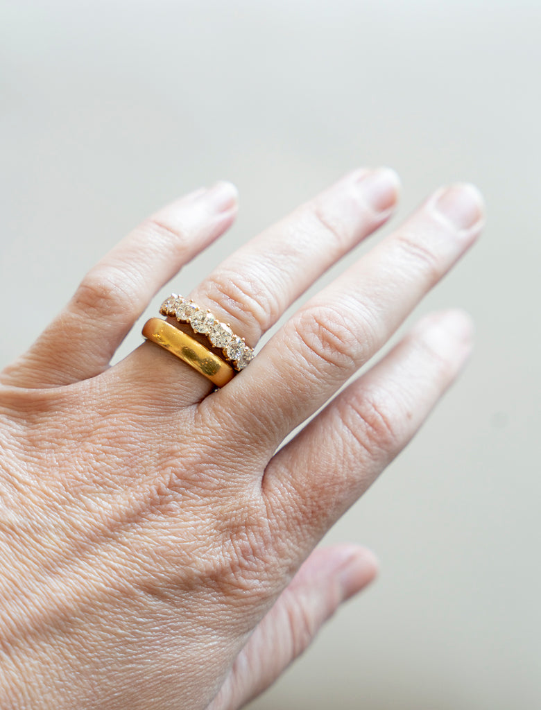 One of our signature designs. Each ring features a unique set of slightly graduated old European cut diamonds. It often takes months to collect a suite of stones in the correct size, color and clarity. This ring features eleven 19th century old European cut diamonds, approximately 2.95 carats in total diamond weight, set in 18k gold. The ring being modeled on a hand along with a 22k gold band.
