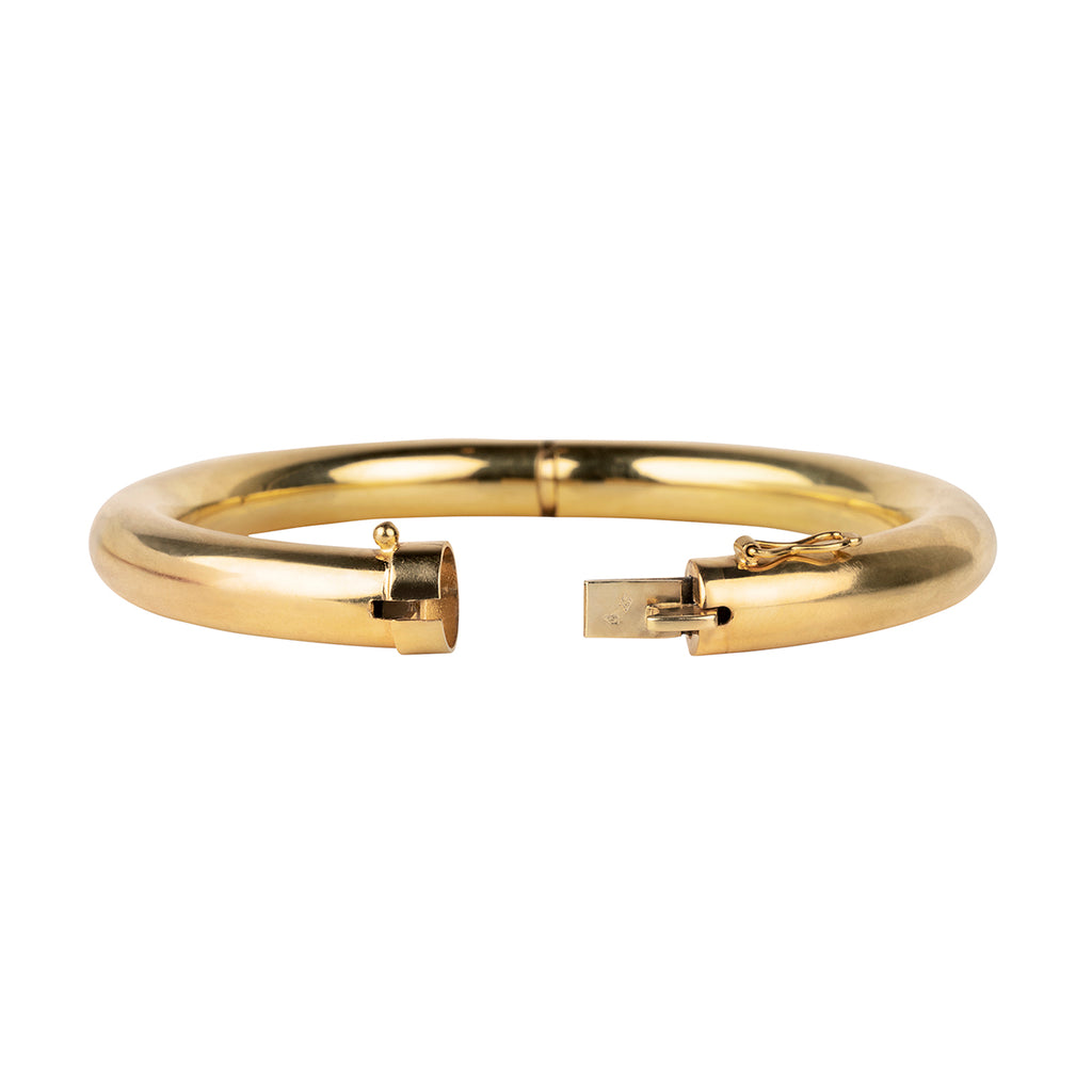 Turn-of-the-century gold tube bangle bracelet in 18k yellow gold. Rich yellow gold bracelets finely constructed with hidden push button clasps.French hallmarks. Circa 1900. Side view with clasp open. 