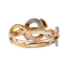 Turn of the century entwined snake ring, in platinum and gold. Hollow construction. There is a small dent on the band next to the platinum snake head. England. Circa 1910.