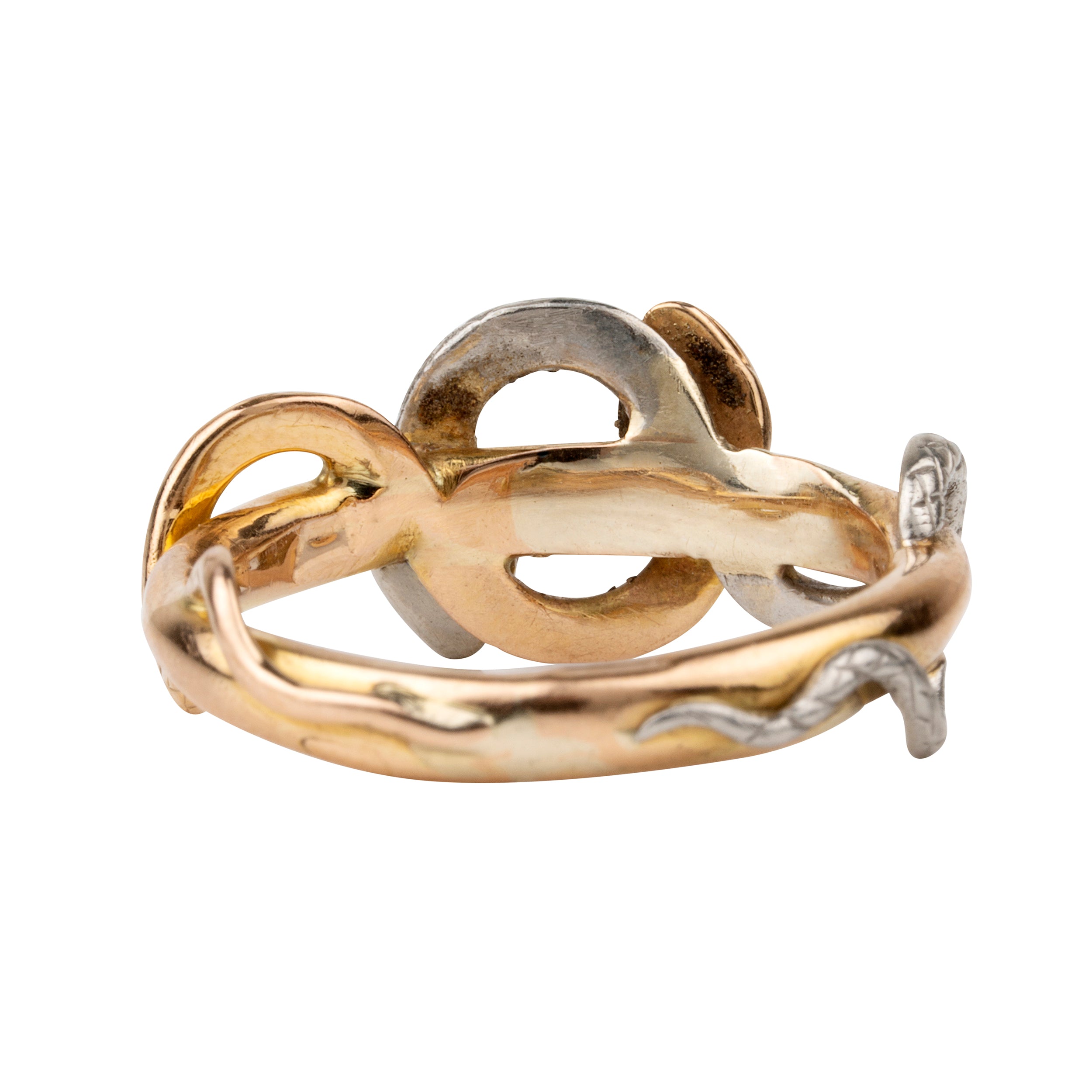 Turn of the century entwined snake ring, in platinum and gold. Hollow construction. There is a small dent on the band next to the platinum snake head. England. Circa 1910.