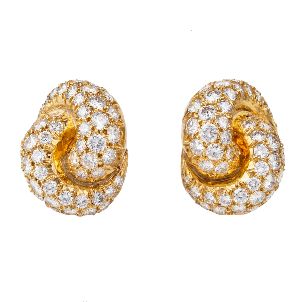 Vintage pave diamond knot earrings. Timeless ear clips in 18k gold. The intertwined loop design is set with approximately 4.50 carats in total diamond weight. The diamonds are estimated to be G to H in color, and VS1 to VS2 clarity. America, circa 1980. Front view. 