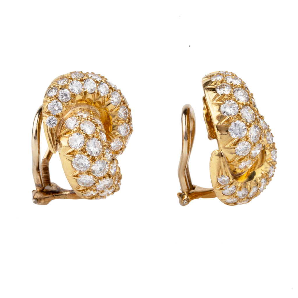 Vintage pave diamond knot earrings. Timeless ear clips in 18k gold. The intertwined loop design is set with approximately 4.50 carats in total diamond weight. The diamonds are estimated to be G to H in color, and VS1 to VS2 clarity. America, circa 1980. Side view. 