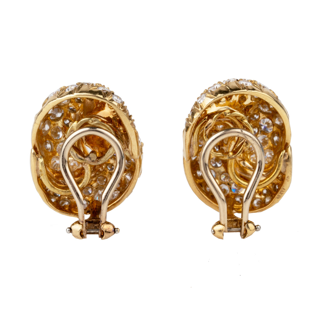 Vintage pave diamond knot earrings. Timeless ear clips in 18k gold. The intertwined loop design is set with approximately 4.50 carats in total diamond weight. The diamonds are estimated to be G to H in color, and VS1 to VS2 clarity. America, circa 1980. Back view. 