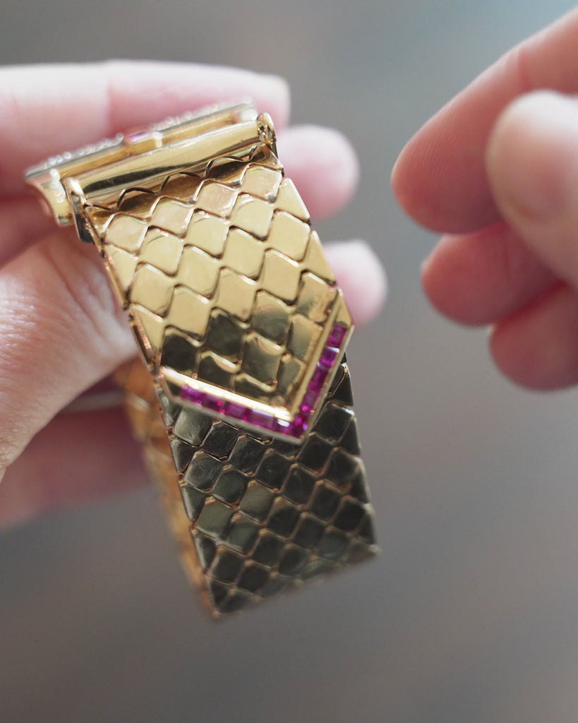 Mid-century gold buckle bracelet with rubies and diamonds in 18k gold. The functional buckle design has an adjustable fit. American in origin. Circa 1940. Bracelet being shown in a video. 