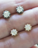 Video of Bell & Bird cutaway diamond earrings in silver and gold being held by a hand to show the scale of the earrings. 
