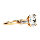 An elegant ring featuring a central old European cut diamond in a simple four-prong setting, flanked by two straight baguettes, all in a custom blend of 18K rose gold.