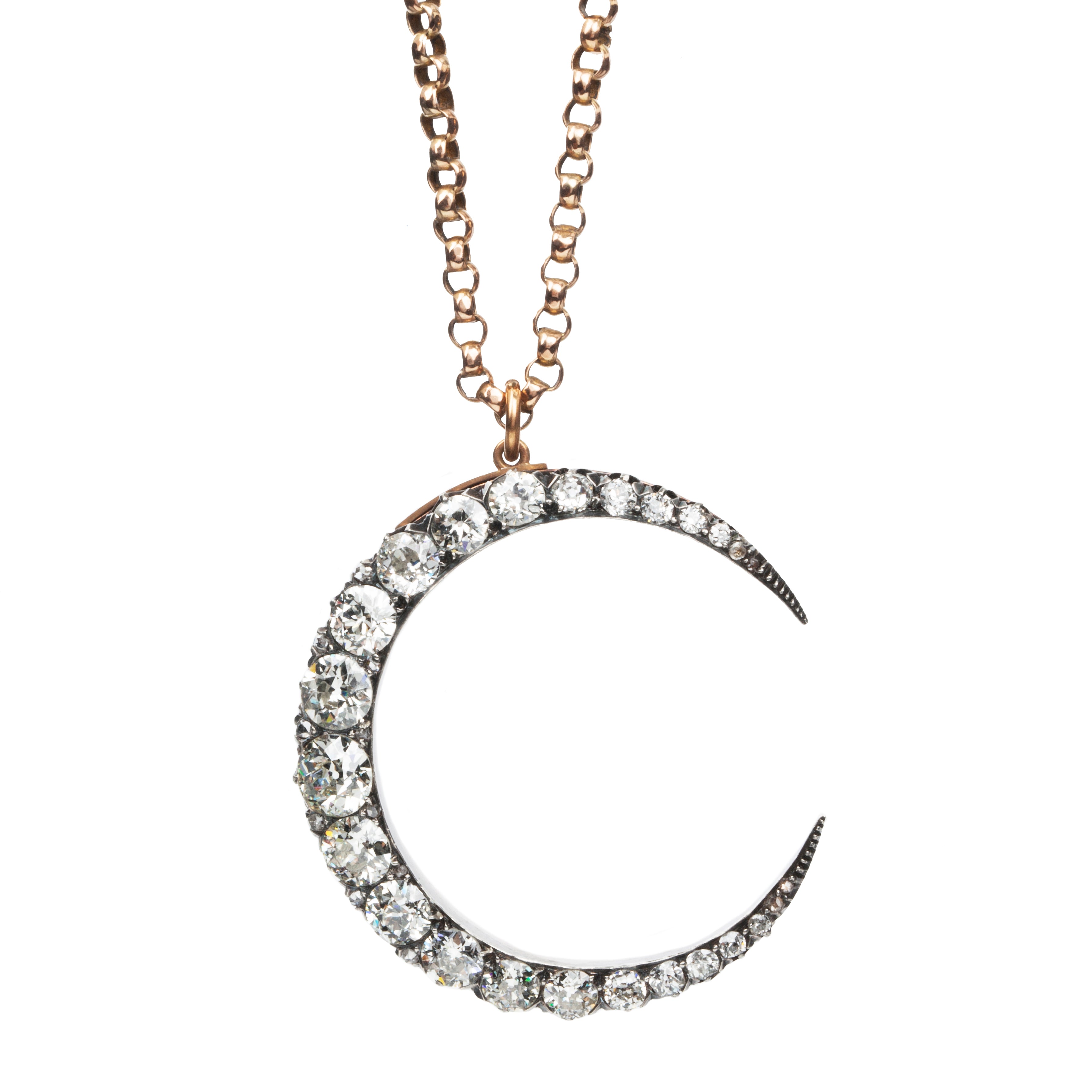 A slender arc of light executed in glittering old mine cut diamonds. Crafted in a silver-topped gold setting this piece has been masterfully constructed to function as a brooch and a pendant with the original fixtures still intact. Approximately 7.20 carats in total diamond weight. English in origin. Front view, hanging on a chain. 