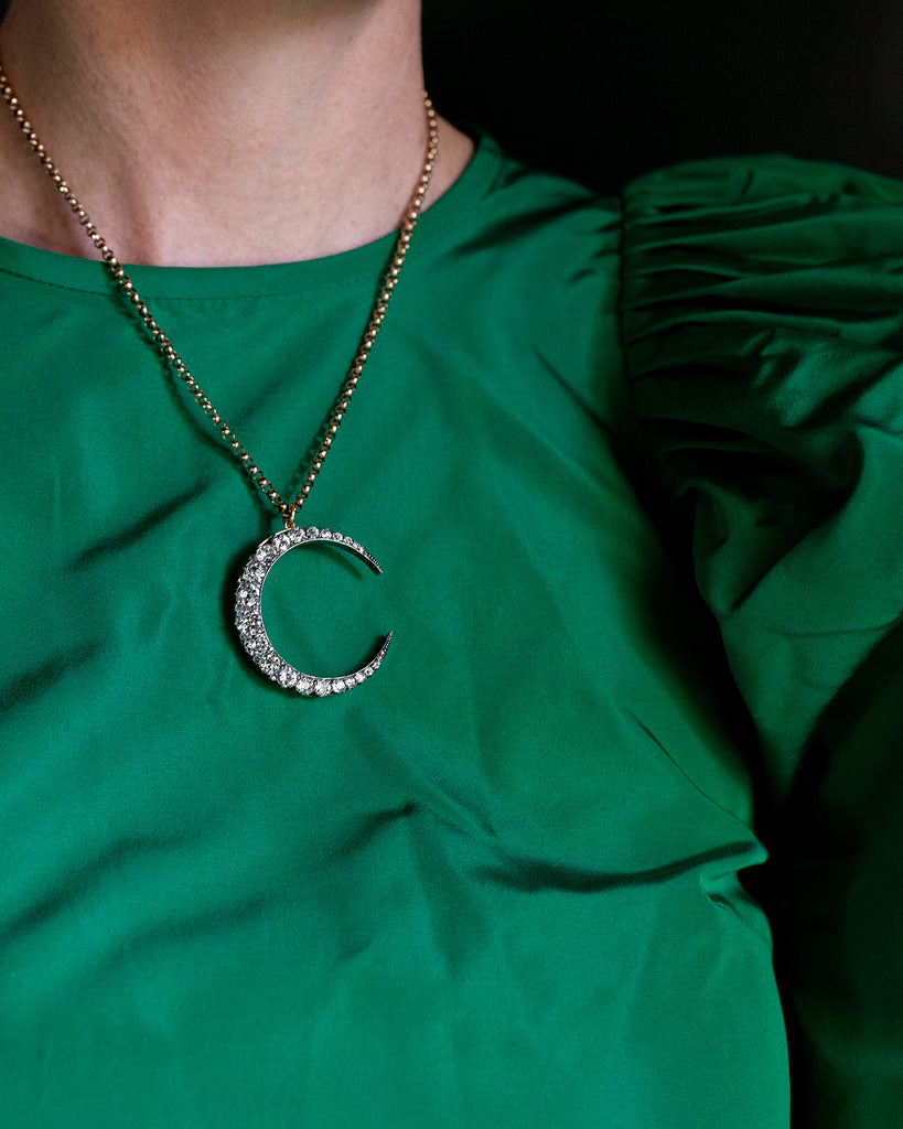 A slender arc of light executed in glittering old mine cut diamonds. Crafted in a silver-topped gold setting this piece has been masterfully constructed to function as a brooch and a pendant with the original fixtures still intact. Approximately 7.20 carats in total diamond weight. English in origin. Being worn on a model.